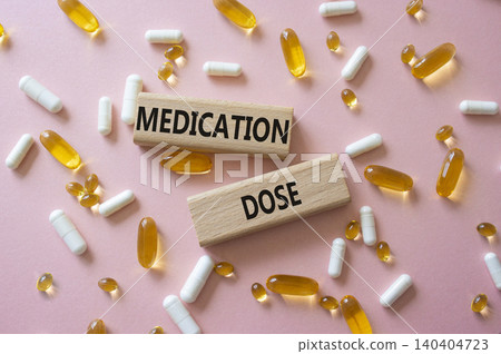 Medication dose symbol. Concept word Medication dose on wooden blocks. Beautiful pink background with pills. Medicine and Medication dose. Copy space Medication dose symbol. Concept word Medication dose on wooden blocks. Beautiful pink background with pills. Medicine and Medication dose. Copy space 140404723