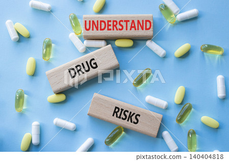 UNDERSTAND DRUG RISKS symbol. Concept words UNDERSTAND DRUG RISKS on wooden blocks. Beautiful blue background with pills. Healthcare and UNDERSTAND DRUG RISKS concept. Copy space. UNDERSTAND DRUG RISKS symbol. Concept words UNDERSTAND DRUG RISKS on wooden blocks. Beautiful blue background with pills. Healthcare and UNDERSTAND DRUG RISKS concept. Copy space. 140404818