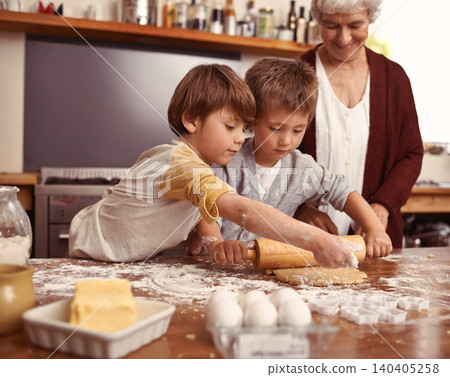Grandma, smile and children baking in kitchen, learning or happy boys bonding together in family home. Grandmother, kids and cooking with flour, rolling pin or teaching brothers with dough at table Grandma, smile and children baking in kitchen, learning or happy boys bonding together in family home. Grandmother, kids and cooking with flour, rolling pin or teaching brothers with dough at table 140405258