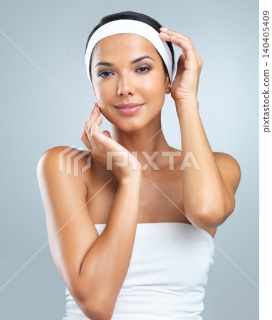 Portrait, woman and skincare in studio with smile in grey background, confident and glow with treatment. Female person, beauty and hygiene with routine for cosmetics, self care and wellness. Portrait, woman and skincare in studio with smile in grey background, confident and glow with treatment. Female person, beauty and hygiene with routine for cosmetics, self care and wellness. 140405409