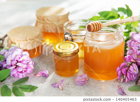 Honey jars with acacia flowers and wooden dipper Honey jars with acacia flowers and wooden dipper 140405463