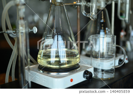 Erlenmeyer Flask with Yellow Liquid Heating on Hot Plate in Chemistry Laboratory Setup Erlenmeyer Flask with Yellow Liquid Heating on Hot Plate in Chemistry Laboratory Setup 140405859