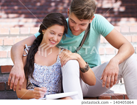 Students, couple and book for writing on steps with smile, hug and support in sunshine at university. People, studying and scholarship for knowledge, education and information with embrace at college 140405864