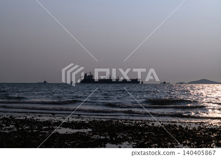 Silhouetted tanker floats offshore under fading light 140405867
