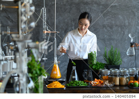 Asian Woman Scientist Extracting Essential Oils from Herbs and Botanicals in Modern Laboratory 140405894