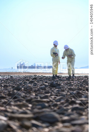 Environmental engineers inspecting coastal area near industrial tanker ship Environmental engineers inspecting coastal area near industrial tanker ship 140405946