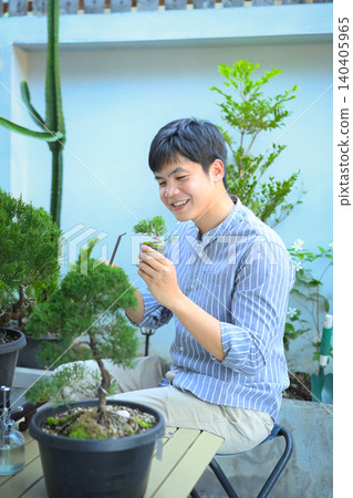 A man making bonsai pruning with precision care and craftsmanship 140405965
