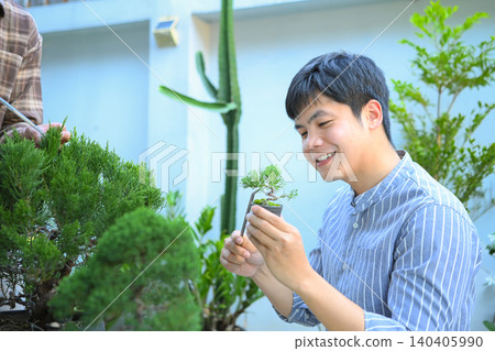 A man making bonsai pruning with precision care and craftsmanship A man making bonsai pruning with precision care and craftsmanship 140405990