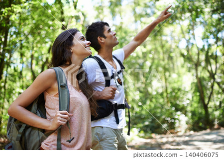 Happy couple, backpack and pointing with direction for sightseeing, destination or hiking together in nature. Young man and woman with smile, bag and showing path or route for trekking in forest 140406075