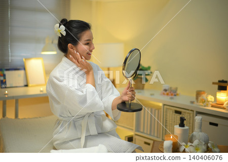 Woman checking skin in mirror at spa room with warm light and calm wellness mood Woman checking skin in mirror at spa room with warm light and calm wellness mood 140406076
