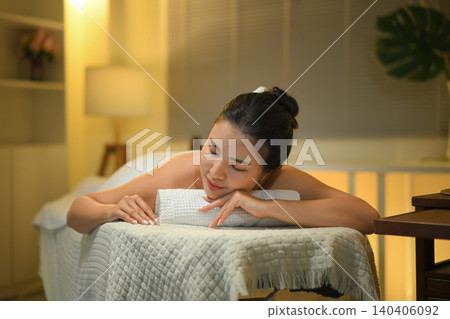 Woman in a lying peacefully on a massage bed with soft lighting. Wellness concept 140406092
