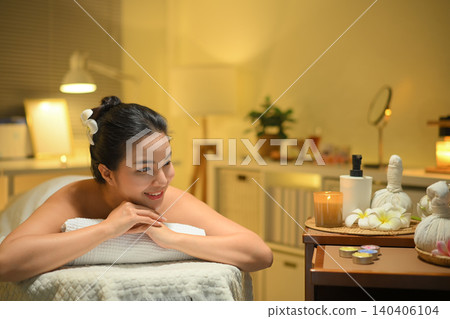 Young woman enjoying relaxing massage therapy at spa, lying on massage table Young woman enjoying relaxing massage therapy at spa, lying on massage table 140406104