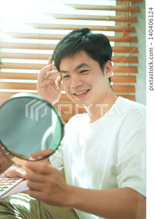 Joyful self expression and confidence at home, Man smiling with glitter makeup in mirror Joyful self expression and confidence at home, Man smiling with glitter makeup in mirror 140406124