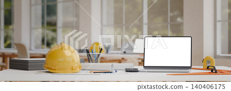 Modern engineering desk with blank laptop screen safety helmet and drafting equipment in office Modern engineering desk with blank laptop screen safety helmet and drafting equipment in office 140406175
