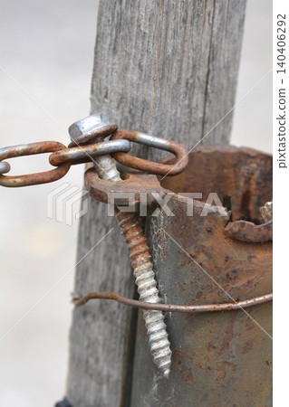 Rusty metal pipe attached to wooden post with a screw Rusty metal pipe attached to wooden post with a screw 140406292