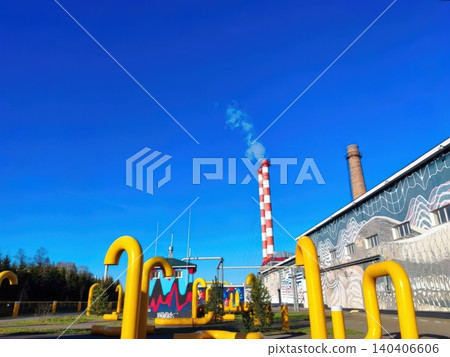 Industrial landscape with smoke stacks and bright yellow pipelines against a clear blue sky Industrial landscape with smoke stacks and bright yellow pipelines against a clear blue sky 140406606