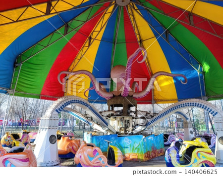 Colorful octopus amusement park ride with vibrant canopy and fun cars 140406625