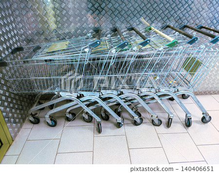 Row of empty shopping carts in a tiled store aisle for retail and consumerism concept Row of empty shopping carts in a tiled store aisle for retail and consumerism concept 140406651