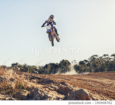 Person, jump and motorbike of professional motorcyclist in the air for trick, stunt or race on outdoor dirt track. Expert rider on bike or scrambler in dunes or extreme sport with blue sky background Person, jump and motorbike of professional motorcyclist in the air for trick, stunt or race on outdoor dirt track. Expert rider on bike or scrambler in dunes or extreme sport with blue sky background 140406762