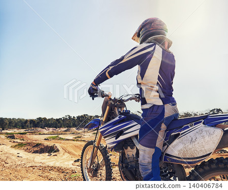 Motorbike, sports and danger with back view of biker person outdoor, sunl with uniform for riding on dirt track. Speed, power and risk with motorcycle, transportation and adventure for adrenaline Motorbike, sports and danger with back view of biker person outdoor, sunl with uniform for riding on dirt track. Speed, power and risk with motorcycle, transportation and adventure for adrenaline 140406784