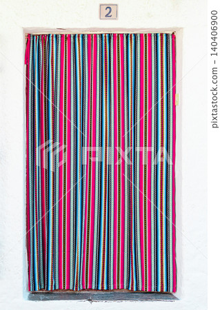 Brightly colored striped curtain covering an entrance in a lively setting 140406900