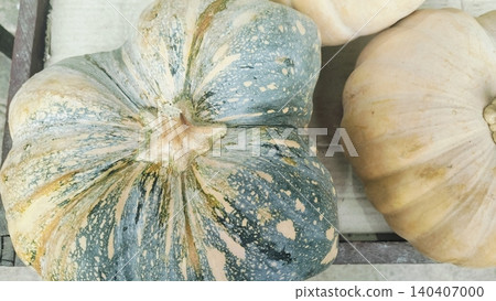 Fresh raw pumpkins on wooden crate at local market Fresh raw pumpkins on wooden crate at local market 140407000