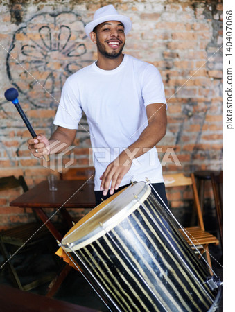 Music, drums or carnival with a happy man playing an instrument in a festival in Rio de Janeiro. Brazil, smile or party with a male musician, performer or artist banging on a drum to create a beat 140407068