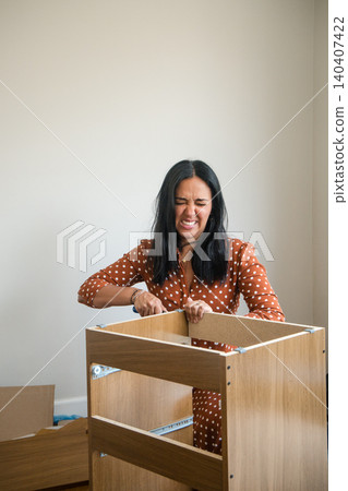 A woman is working on a wooden box, and she is wearing a polka dot dress A woman is working on a wooden box, and she is wearing a polka dot dress 140407422