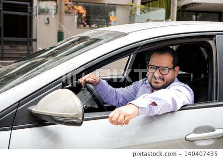 A man in a white car is smiling and holding his hand up A man in a white car is smiling and holding his hand up 140407435