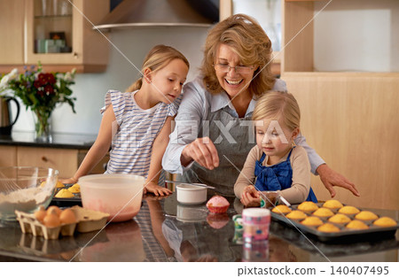Grandma, kid and baking with teaching, smile and decorating for cheerful bonding together at home. Happy, pensioner or girl child with cupcake, laugh or icing for creative, playful or fun in kitchen Grandma, kid and baking with teaching, smile and decorating for cheerful bonding together at home. Happy, pensioner or girl child with cupcake, laugh or icing for creative, playful or fun in kitchen 140407495