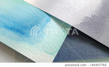 Close-up of layered watercolor paper sheets curling with teal and green wash 140407768