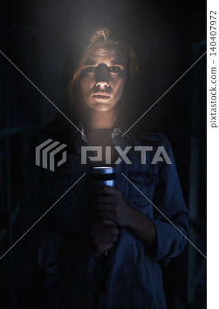 Portrait, horror and torch for light with woman on black background to hide from fear, panic or terror. Stress, depression and mental health with scared young person in dark for danger or violence Portrait, horror and torch for light with woman on black background to hide from fear, panic or terror. Stress, depression and mental health with scared young person in dark for danger or violence 140407972