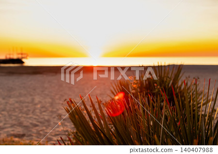 Vibrant orange sunset in the empty beach by the sea. Vibrant orange sunset in the empty beach by the sea. 140407988