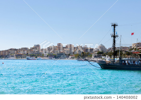 Black ship on the blue waters of Sarande marina in summer. Black ship on the blue waters of Sarande marina in summer. 140408002