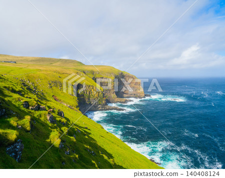 Scenic summer landscape of Faroe Islands with green fields, meadows and rocky cliffs by the ocean. Scenic summer landscape of Faroe Islands with green fields, meadows and rocky cliffs by the ocean. 140408124