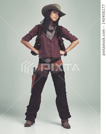 Woman, cowgirl and portrait in studio for western costume with confidence on grey background, weapon or outlaw. Female person, wild and hat with mockup space in Texas for dress up, old west or rodeo Woman, cowgirl and portrait in studio for western costume with confidence on grey background, weapon or outlaw. Female person, wild and hat with mockup space in Texas for dress up, old west or rodeo 140408177