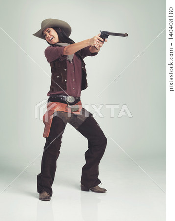 Western, woman and cowboy with gun in studio for fashion, nervous and scared to shoot on grey background. Female person, vintage and outlaw with pistol for wild west, costume and character with hat 140408180