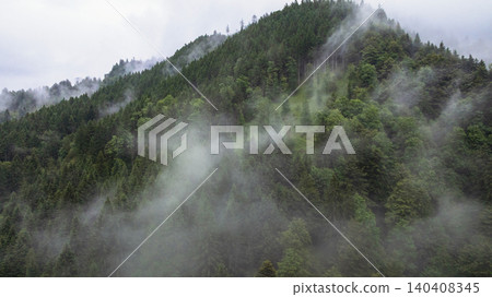 Spectacular drone overview reveals high mountain ridges along border of Austria and Slovenia. Massive Alpine peaks, deep valleys, and evergreen forests dominate majestic European landscape. Spectacular drone overview reveals high mountain ridges along border of Austria and Slovenia. Massive Alpine peaks, deep valleys, and evergreen forests dominate majestic European landscape. 140408345