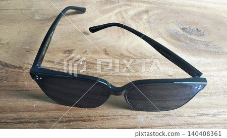 Black Oversized Sunglasses on Wooden Surface Close-Up Black Oversized Sunglasses on Wooden Surface Close-Up 140408361