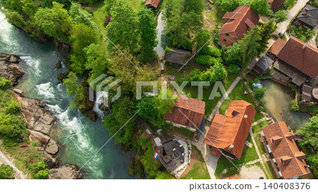 Drone captures beautiful canyon village of Rastoke near Slunj. Rapid rivers, waterfalls, and traditional wooden watermills integrate perfectly with lush green nature in famous Croatian landmark. Drone captures beautiful canyon village of Rastoke near Slunj. Rapid rivers, waterfalls, and traditional wooden watermills integrate perfectly with lush green nature in famous Croatian landmark. 140408376