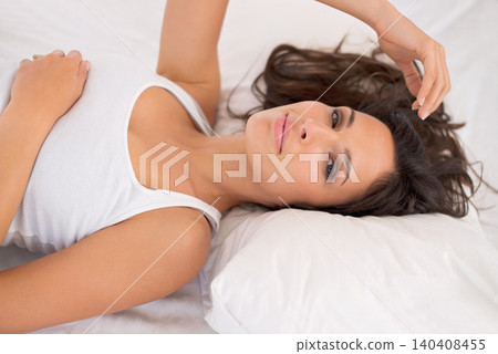 Portrait, relax and woman on bed in home for peace or resting in the morning alone in house. Face, healthy and young person in bedroom on comfortable pillow, wakeup and calm in apartment in Australia 140408455