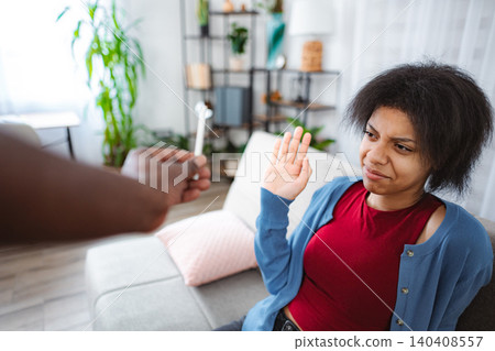 Young woman refusing drugs offered by a friend at home 140408557