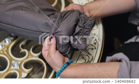 Hands examining jacket sleeve detail, showing elastic cuff and fabric quality Hands examining jacket sleeve detail, showing elastic cuff and fabric quality 140408682