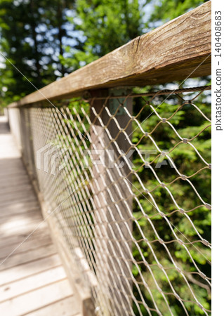 Wooden railing on forest walkway with blurred background Wooden railing on forest walkway with blurred background 140408683