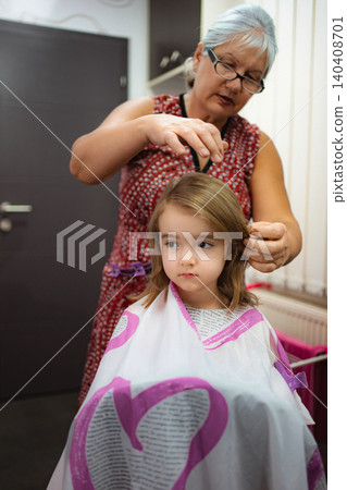 Grandmother cutting granddaughter's hair, bonding and learning Grandmother cutting granddaughter's hair, bonding and learning 140408701