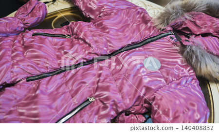 Pink down jacket with fur collar hood and shiny fabric, warm winter outerwear Pink down jacket with fur collar hood and shiny fabric, warm winter outerwear 140408832
