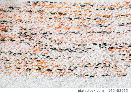 Abstract woven textile texture with white, orange and dark yarn details 140408915