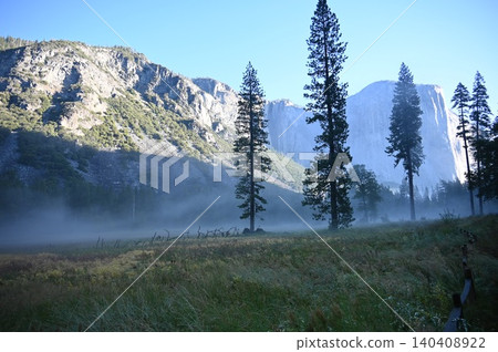 Morning mist over Yosemite Valley meadow with El Capitan and pine trees. Morning mist over Yosemite Valley meadow with El Capitan and pine trees. 140408922