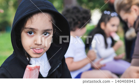 Happy little girl enjoying strawberry popsicle sticking out tongue Happy little girl enjoying strawberry popsicle sticking out tongue 140408941