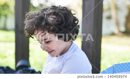 Young boy with curly hair smiling and laughing outdoors on a sunny day Young boy with curly hair smiling and laughing outdoors on a sunny day 140408974